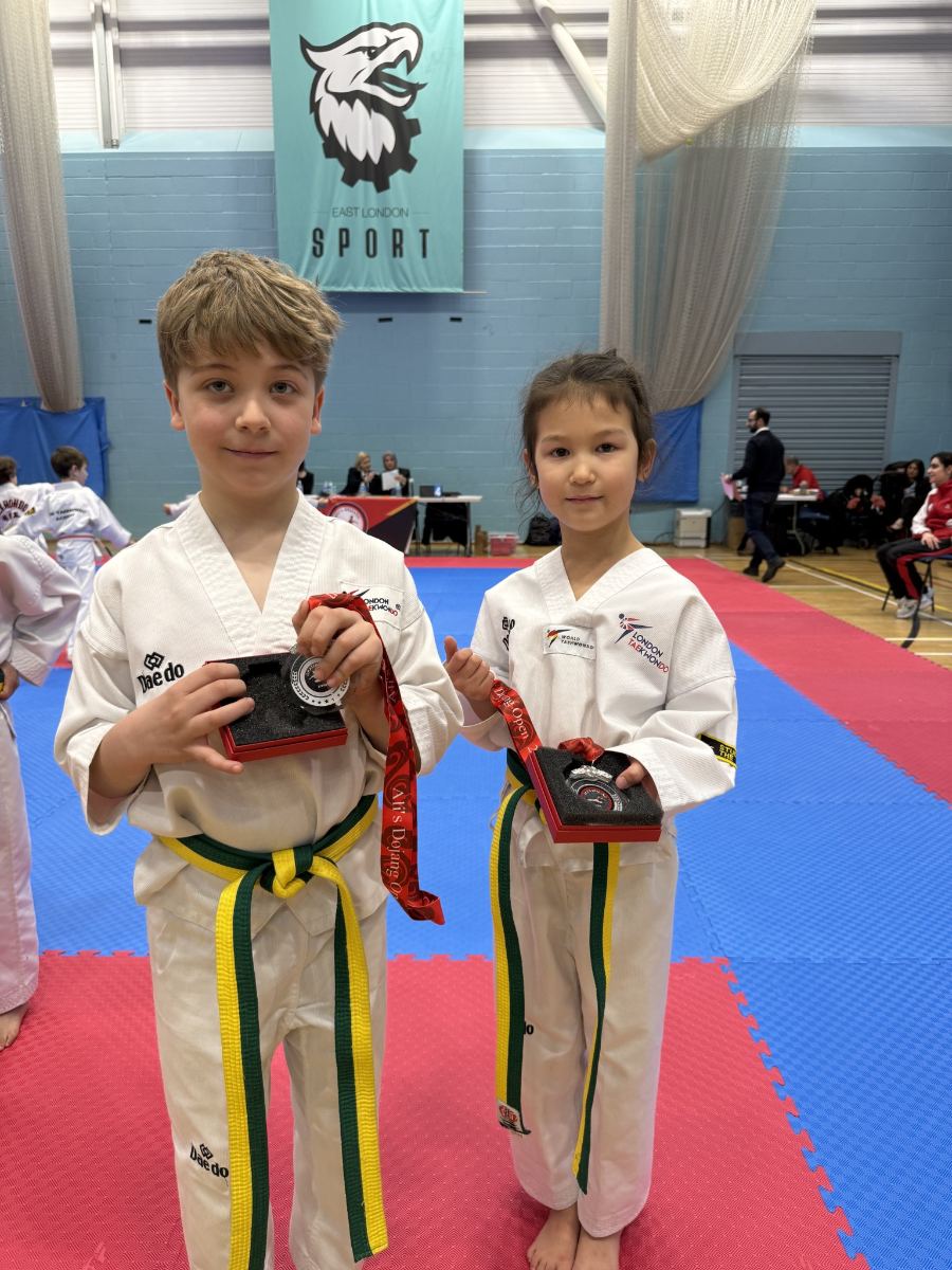 Two students holding their medals