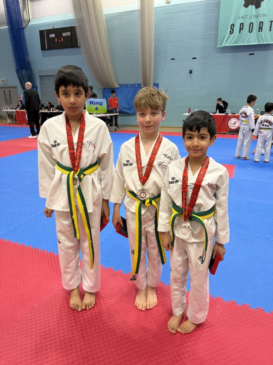 Three students wearing silver medals