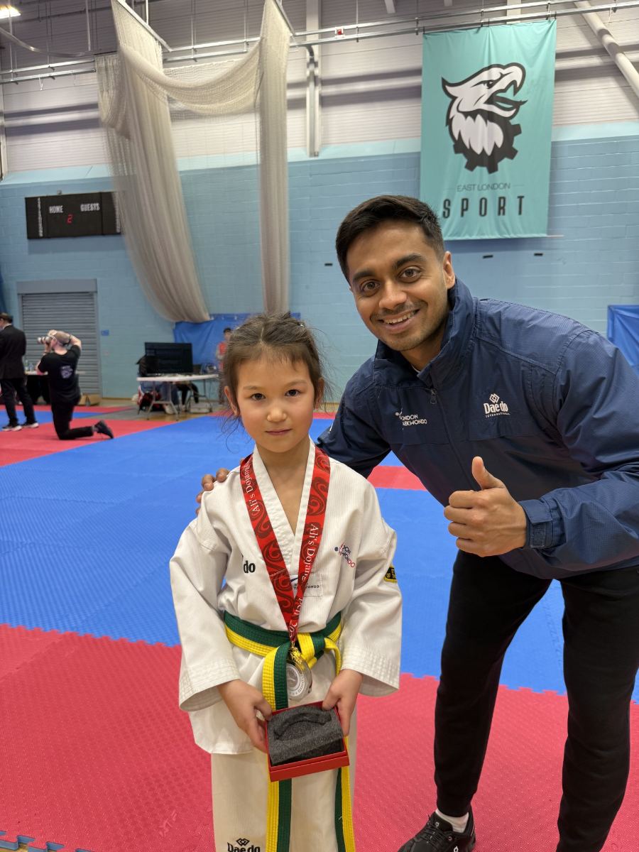 Young student with a medal beside the head coach