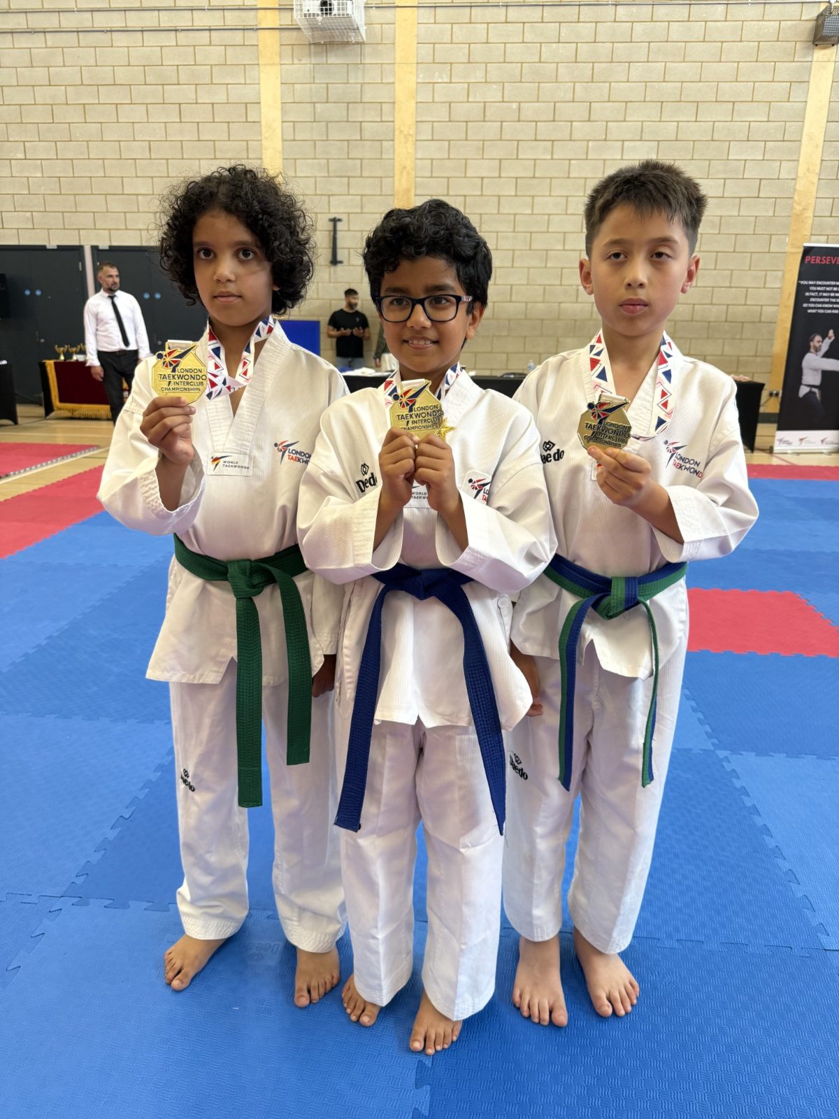 Three Panthers students holding gold medals at the LTA InterClub Poomsae Championship