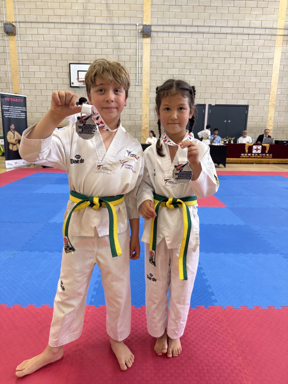 Two students holding up silver medals