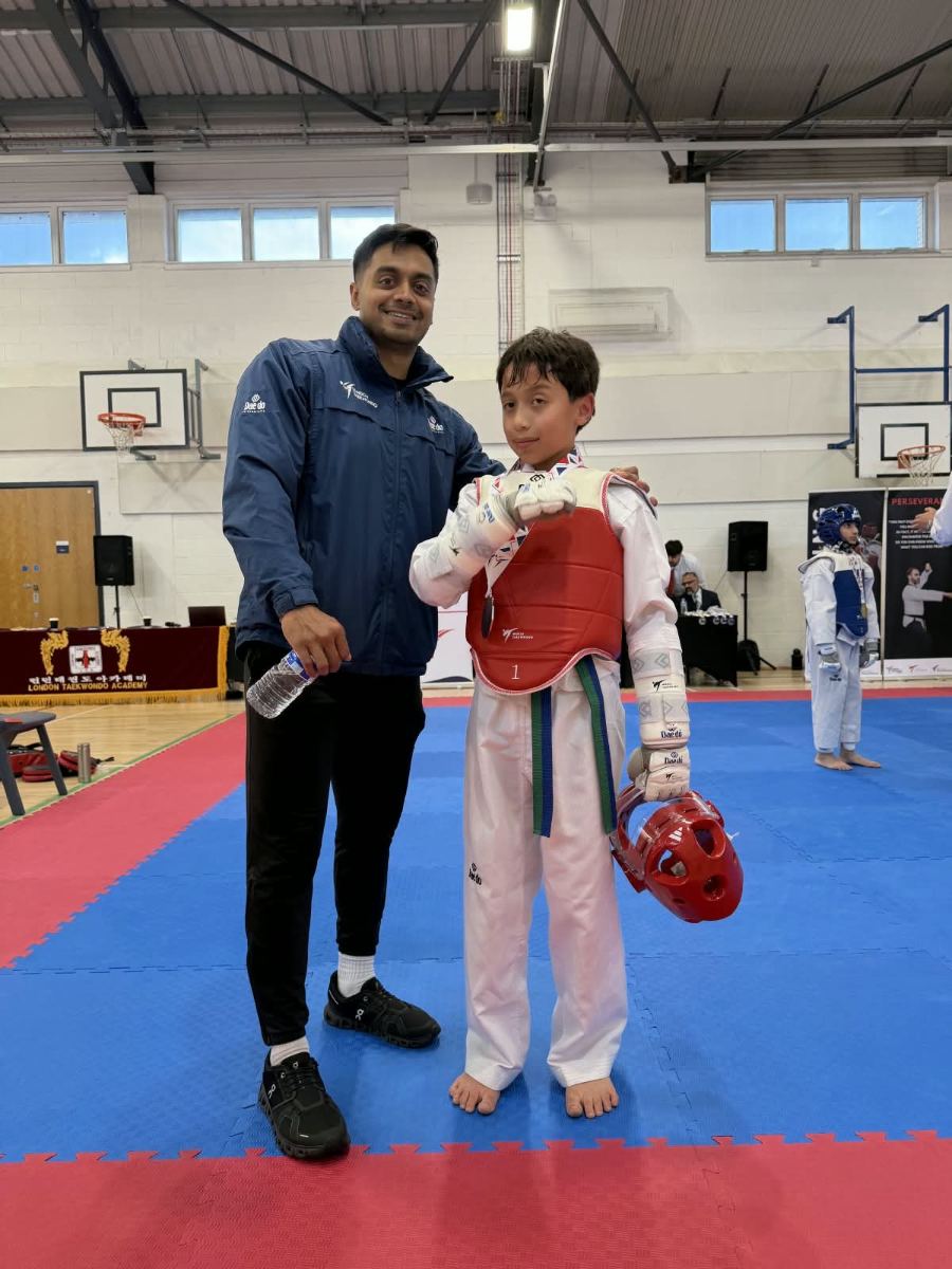 Student in red sparring kit with the head coach