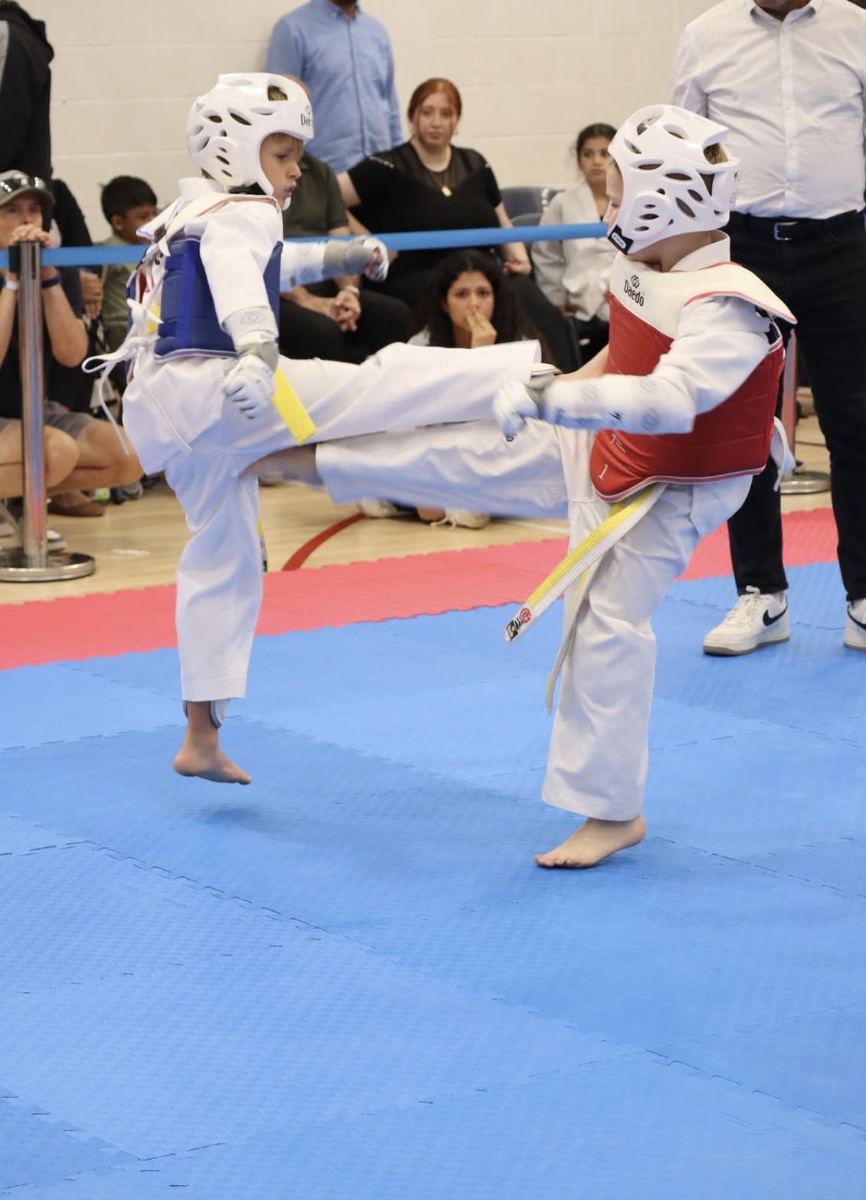 Two young students exchanging kicks during a bout
