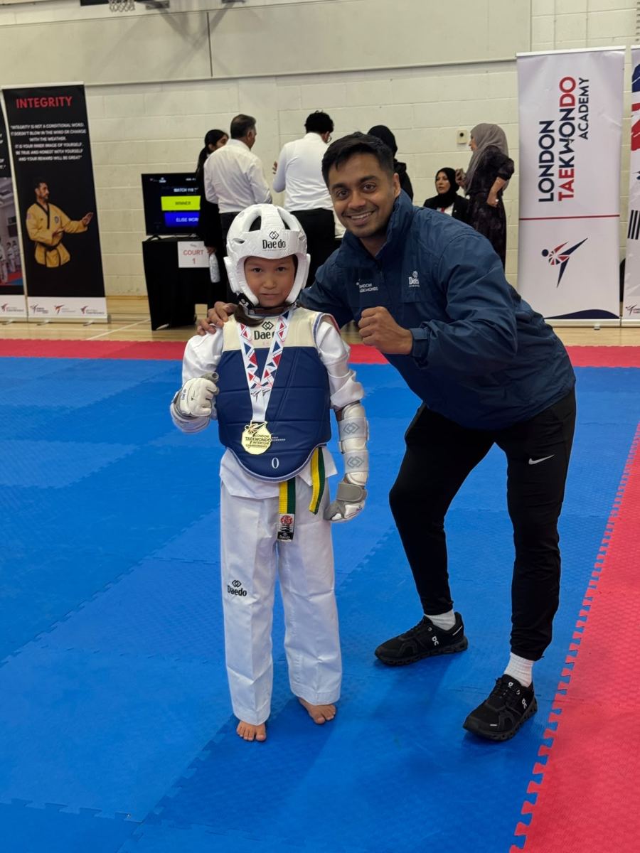 Young student in blue sparring kit with a gold medal
