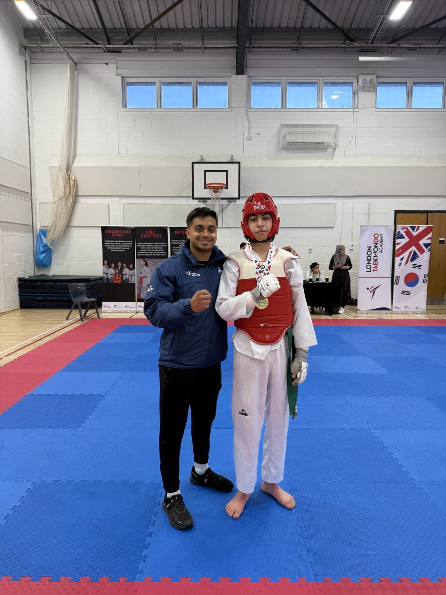 Teen student in red head guard with a gold medal