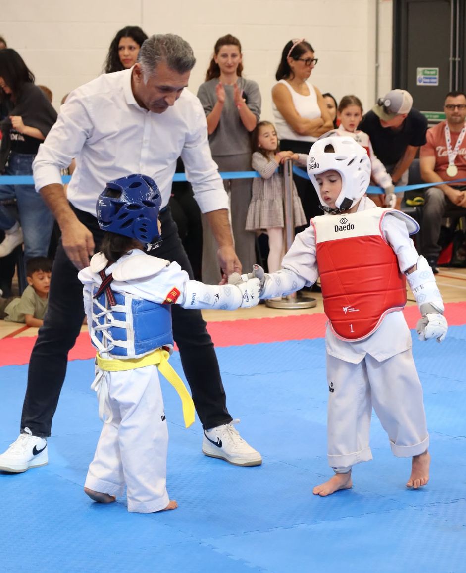 Two young students touching gloves before a bout